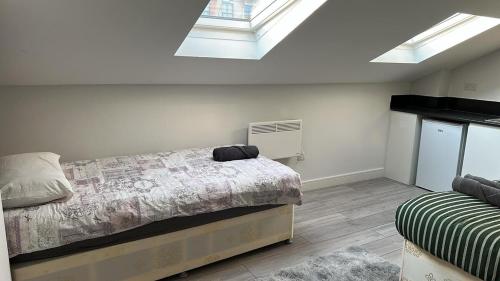 a bedroom with a bed and two skylights at Bright Studio on Brigstock Rd in Thornton Heath