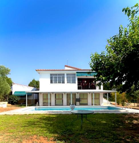 a white house with a table in the yard at Finca Azafrán - Chalet con piscina privada in Sanlúcar la Mayor
