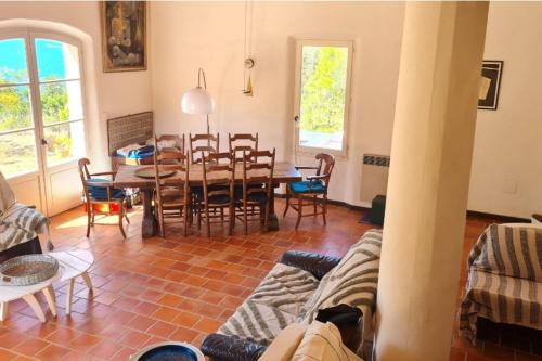 a living room with a table and chairs at Magnificent house with sea view in Ajaccio in Porticcio
