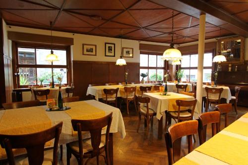 a dining room with tables and chairs and windows at Landgasthof Zur Sonne in Enkirch