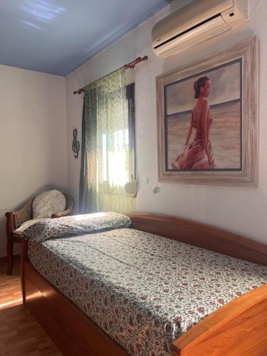 a bedroom with a bed and a painting on the wall at Finca Azafrán - Chalet con piscina privada in Sanlúcar la Mayor