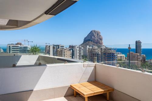 a bench on a balcony with a view of the ocean at Saeta 13B Calpe in Calpe