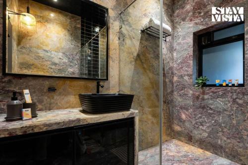 a bathroom with a sink and a shower at StayVista at Isolaire with Bonfire, Infinity Pool in Āmbavna