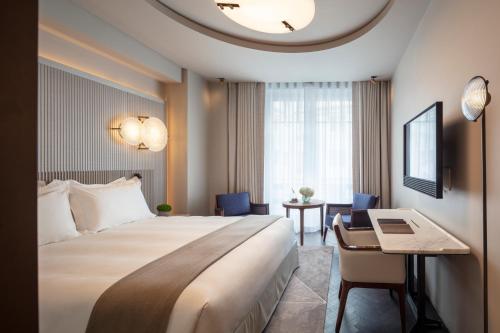 a hotel room with a large bed and a desk at Mandarin Oriental Lutetia, Paris in Paris