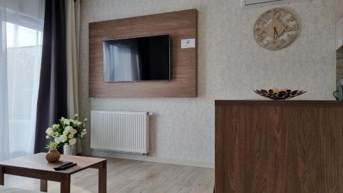a living room with a tv on the wall at Q Apart Orion - dwupokojowy, klimatyzowany apartament przy Manufakturze z darażem Gratis, FV in Łódź