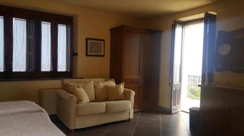 a living room with a couch and a window at Antico Borgo Petralia in Zafferana Etnea