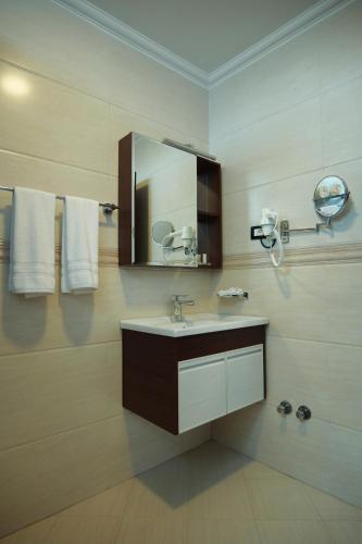 a bathroom with a sink and a mirror and towels at Crescent International Hotel in Addis Ababa