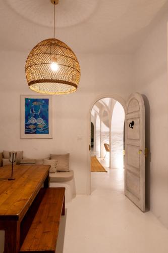 a living room with a table and a chandelier at Villa Kenzy Djerba in Houmt Souk