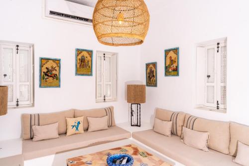 a living room with a couch and a table at Villa Kenzy Djerba in Houmt Souk