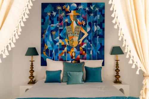 a bedroom with a bed with a painting on the wall at Villa Kenzy Djerba in Houmt Souk