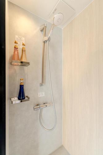 a shower with a shower head in a bathroom at 楽途ホテル 東十条 in Tokyo