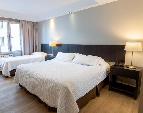 サン・カルロス・デ・バリローチェにあるホテル アルト インターラーケンのベッド2台とランプ2台があるホテルの部屋