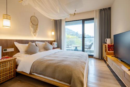 a bedroom with a large bed and a television at Siguniangshan Town Tingshan Wild Luxury B&B in Mount Siguniang