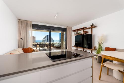 a kitchen with a large counter top in a living room at Saeta 13B Calpe in Calpe