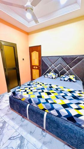 a bedroom with a bed with a checkered bedspread at RESIDENCE PHs 2 in Ouagadougou