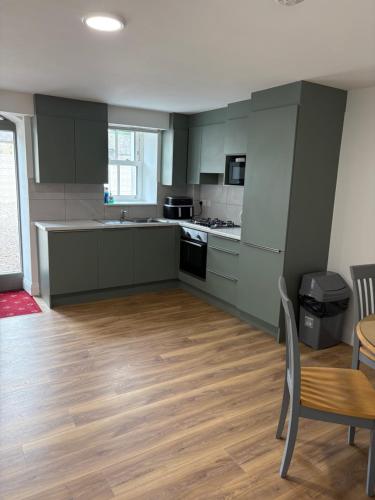 a kitchen with green cabinets and a table and chairs at The Courtyard Apartments in Macroom