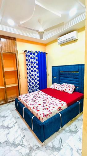 a bedroom with a bed with a red and blue comforter at RESIDENCE PHs 2 in Ouagadougou