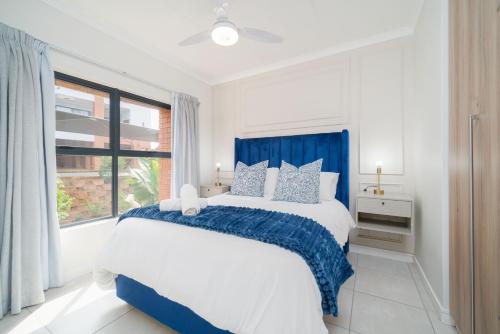 a white bedroom with a large bed and a window at Ballito Hills 164 in Ballito