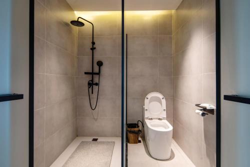 a shower stall with a toilet in a bathroom at Siguniangshan Town Tingshan Wild Luxury B&B in Mount Siguniang