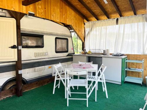 a table and chairs in front of an rv at Къмпинг Alino Lake in Alino