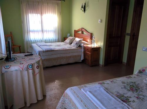 ein Schlafzimmer mit zwei Betten und einem Fernseher darin in der Unterkunft Casa Rural Rosa in Villafruel