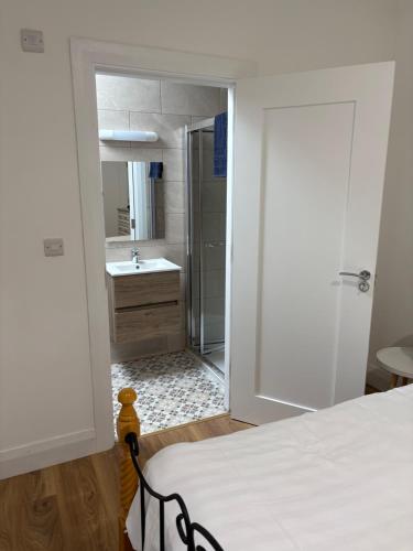 a bedroom with a bed and a bathroom with a shower at The Courtyard Apartments in Macroom