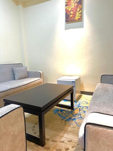 a living room with a table and two couches at KIjichi gateway Hotel in Dar es Salaam