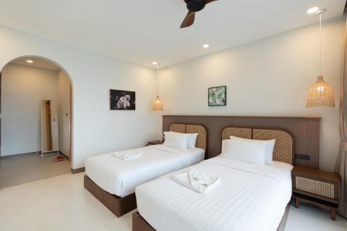 Postel nebo postele na pokoji v ubytování ENNKAI Beachfront Resort Koh Larn