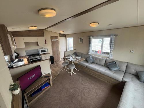a living room with a couch and a table at Whitstable, CW18, 2 bed park home, Alberta Holiday Park in Seasalter