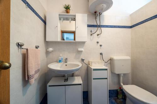 a small bathroom with a sink and a toilet at Apartments Soni in Postira