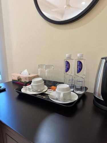 a tray with plates and glasses on a table at KIjichi gateway Hotel in Dar es Salaam
