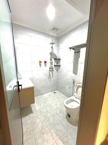 a white bathroom with a toilet and a sink at KIjichi gateway Hotel in Dar es Salaam