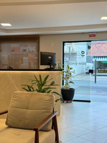 a lobby with a chair in front of a store at Hotel Graju Itajaí in Itajaí