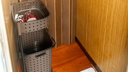 a trash can in a corner of a room at 木の家ゲストハウス郡山別館 in Koriyama