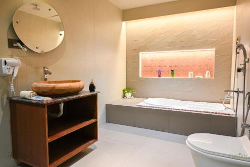 a bathroom with a sink and a tub and a toilet at The Elysian Boutique Stays - Havelock in Havelock Island
