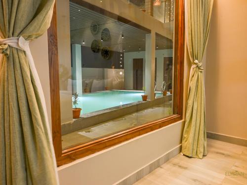 a bathroom with a swimming pool and a mirror at The Elysian Boutique Stays - Havelock in Havelock Island