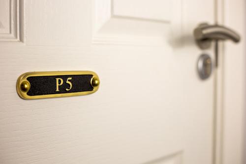 a doorhandle to a white door with the wordsps on it at The Old School House in Haltwhistle