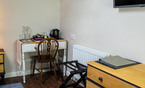 a room with a desk with a chair and a table and a chair at The Old School House in Haltwhistle