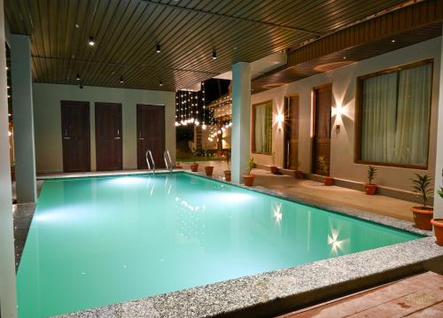 a swimming pool with blue lighting in a house at The Elysian Boutique Stays - Havelock in Havelock Island