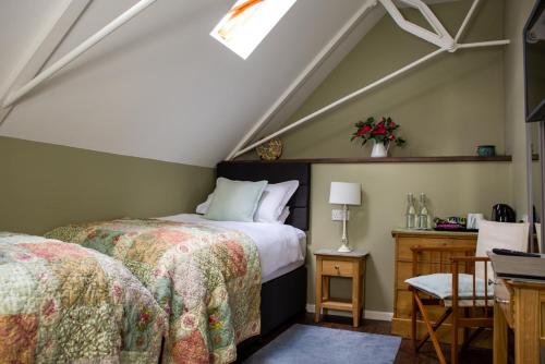 a attic bedroom with two beds and a window at The Old School House in Haltwhistle