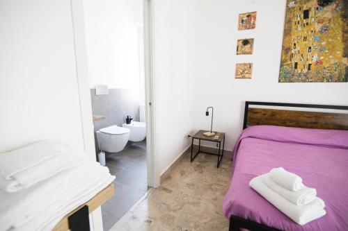 a bedroom with a purple bed and a bathroom at Al ventitré in Reggio Calabria