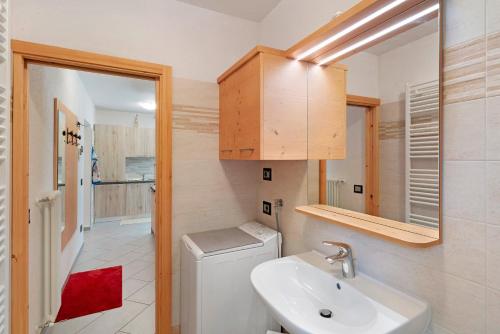 a bathroom with a sink and a toilet and a mirror at Appartamento Nuovo A San Giovanni in Pozza di Fassa