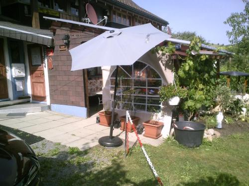 a white umbrella in front of a building at Wannenhof Romantik in Bernau im Schwarzwald