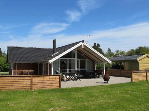 a house with a porch and a man standing in front of it at 8 person holiday home in Idestrup-By Traum in Marielyst