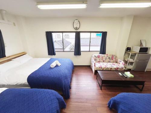 a bedroom with two beds and a couch and a clock at Ueno-Tokyo Garden in Tokyo