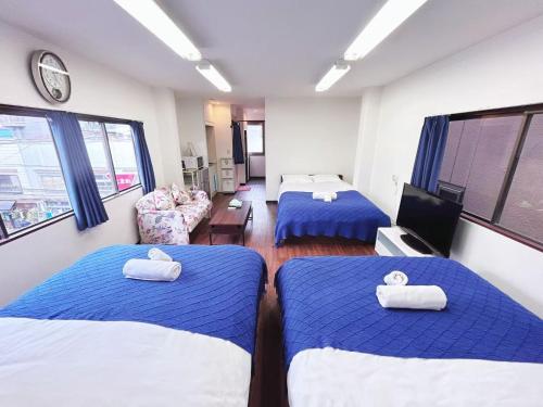 two beds in a room with blue and white sheets at Ueno-Tokyo Garden in Tokyo