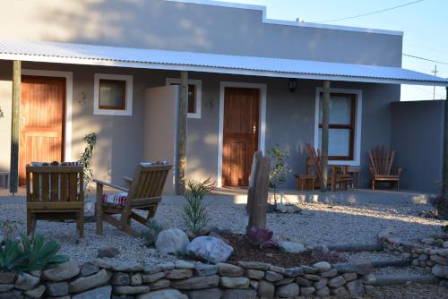 a house with two chairs in front of it at Travellers Rest in Prince Albert