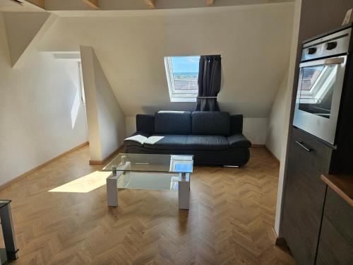 a living room with a couch and a glass table at Rooftop Retreat Heilbronn in Heilbronn