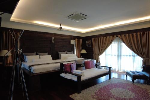 a bedroom with a bed and a couch and a window at Villa D'Acqua in Masjid Tanah