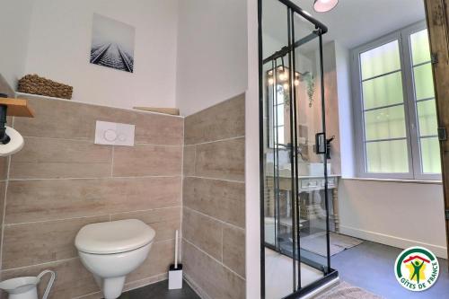 a bathroom with a toilet and a glass shower at gite de la gare in Épinouze